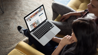 coworkers-working-on-a-macbook-mockup-while-talking-about-it