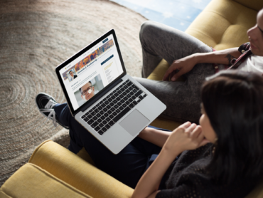 coworkers-working-on-a-macbook-mockup-while-talking-about-it